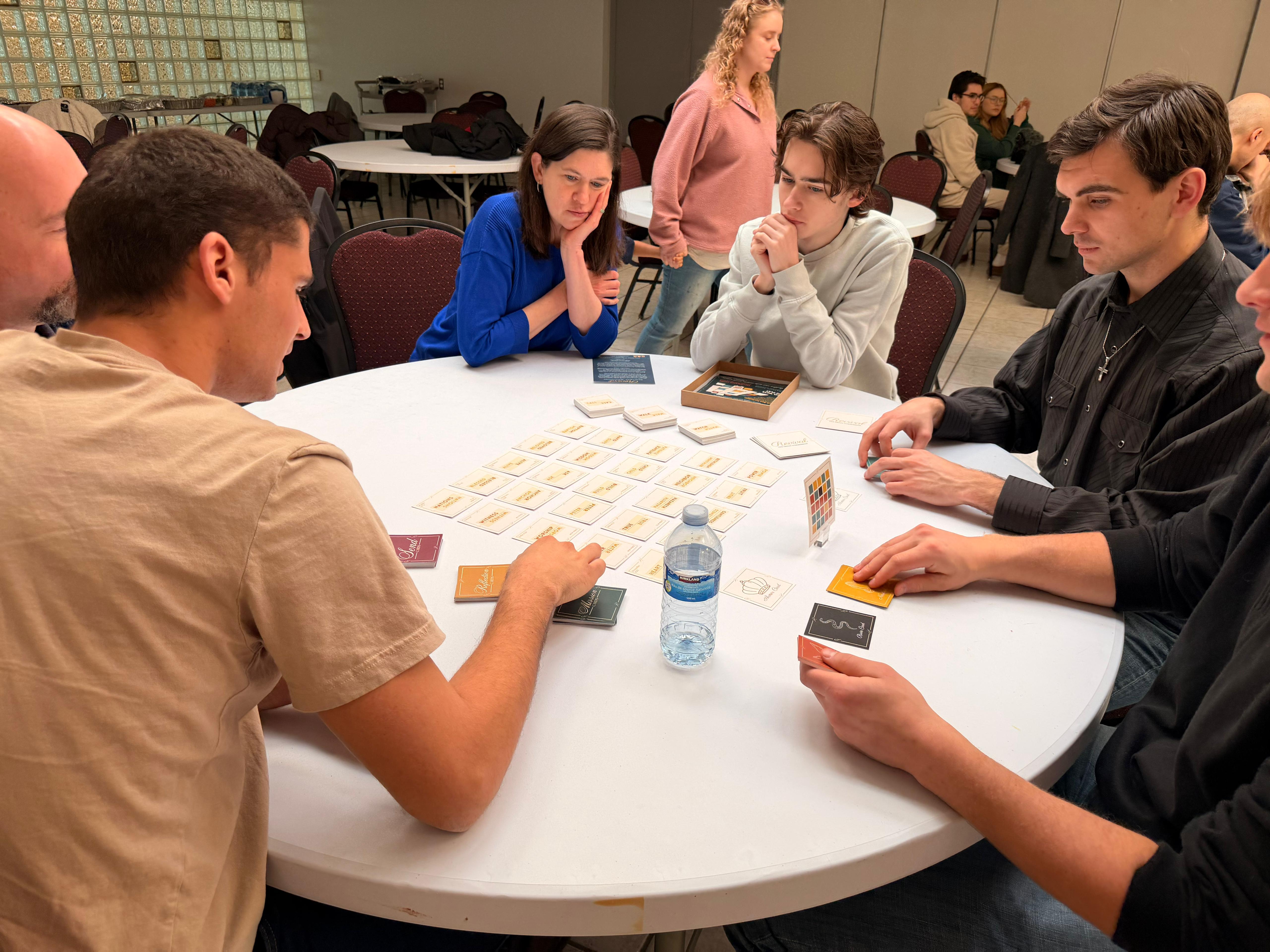 Church event gameplay — focused players around a round table